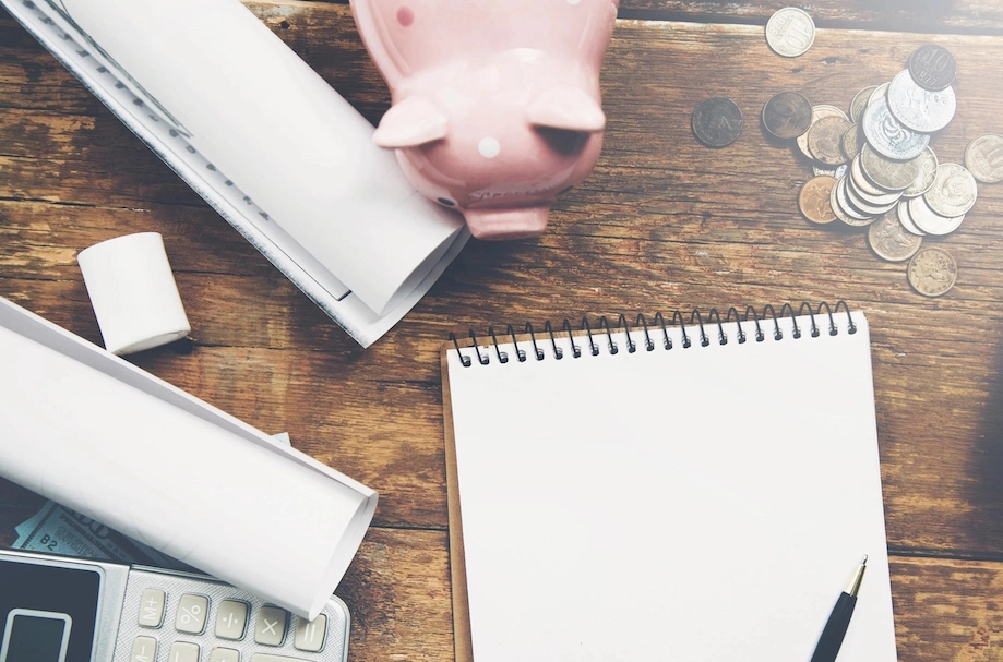 desk with piggy bank, calculator, and notebook